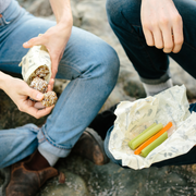 Hikers snack outdoors using their light Abeego waxed food wrap.